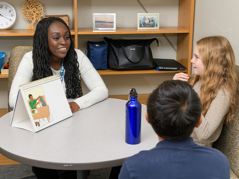 School psychology student speaks with two students at The College School