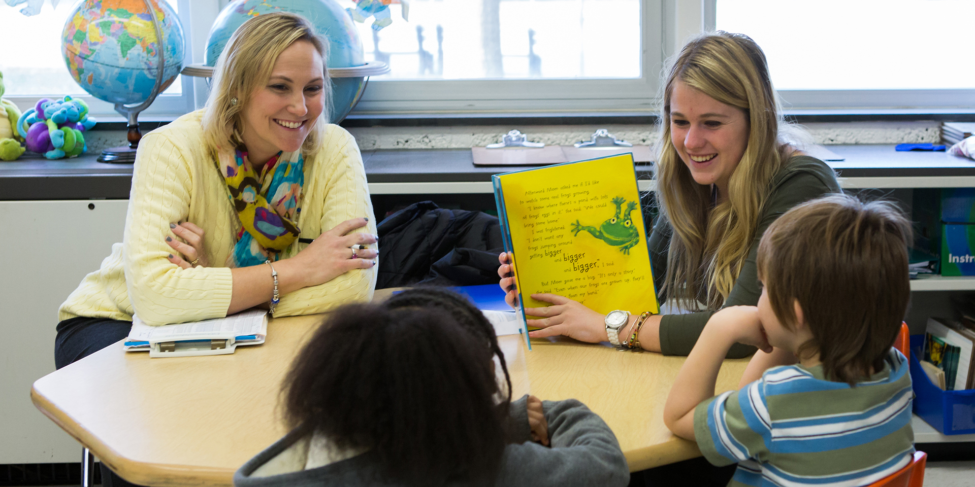 Two student teachers read to children