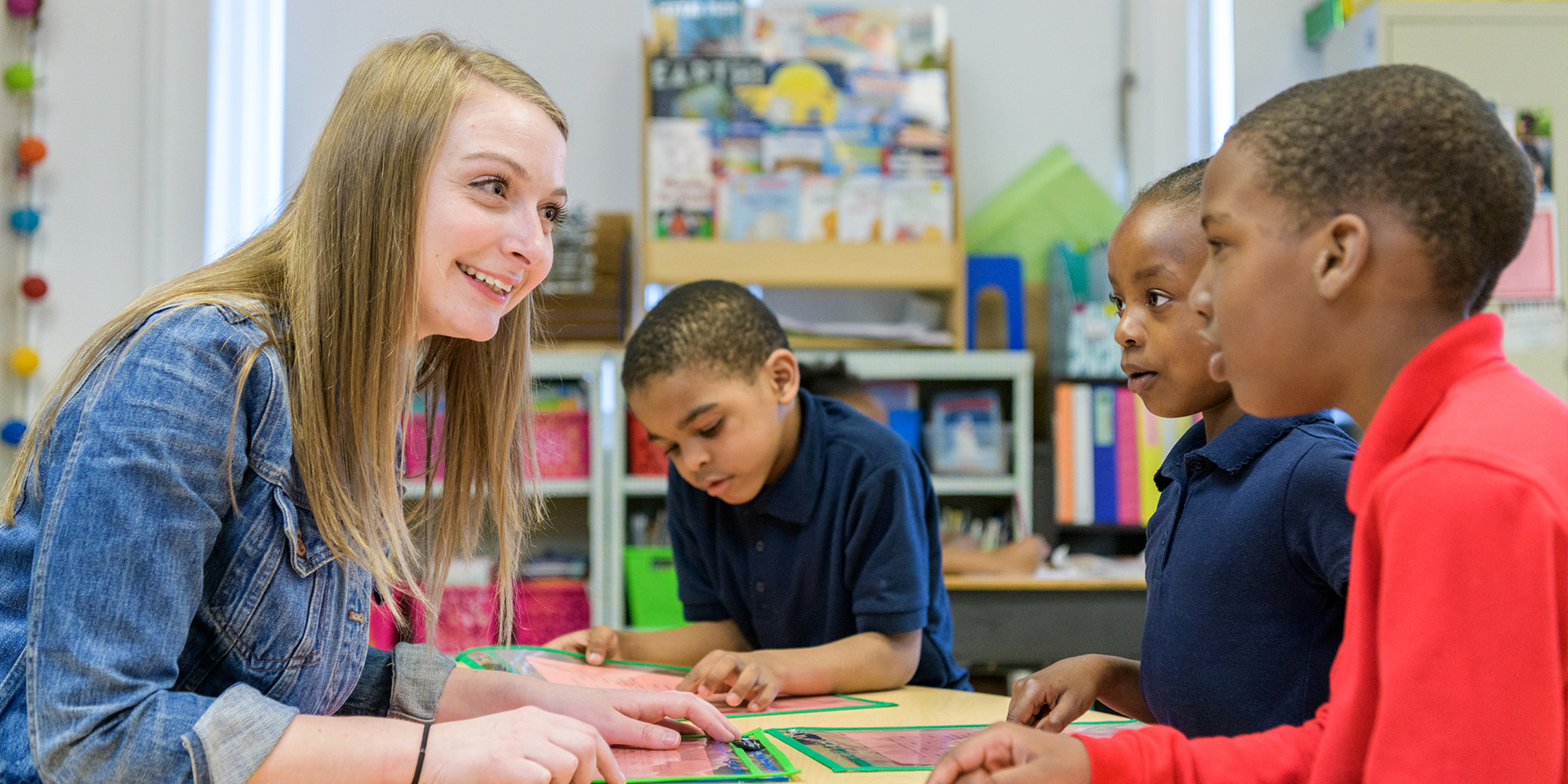 Student teacher speaking to three children